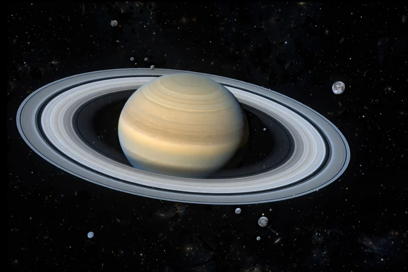 Saturn and its rings with many small distant moons in deep space
