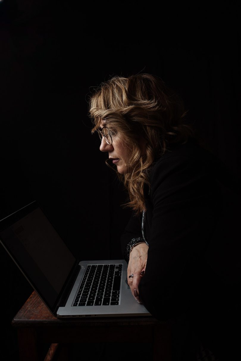 A blogger writing on a laptop late at night