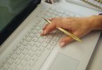 A blogger's workspace with a laptop, notebook and tools laid out