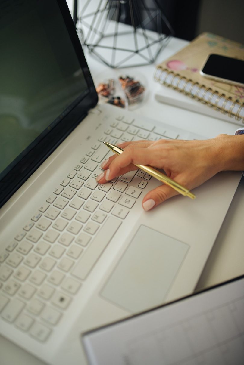 A blogger's workspace with a laptop, notebook and tools laid out